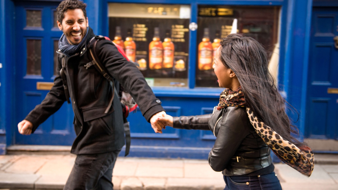 Couple running through Dublin's Temple Bar.